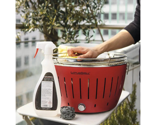 Detergent de curățare grătar Lotusgrill cu grătar Lotusgrill roșu, burete și lână de oțel pe o masă