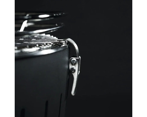 Imagine detaliată a unui grătar pe cărbune cu capac și închidere