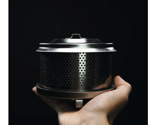 Filtru de cafea metalic cu capac ținut într-o mână