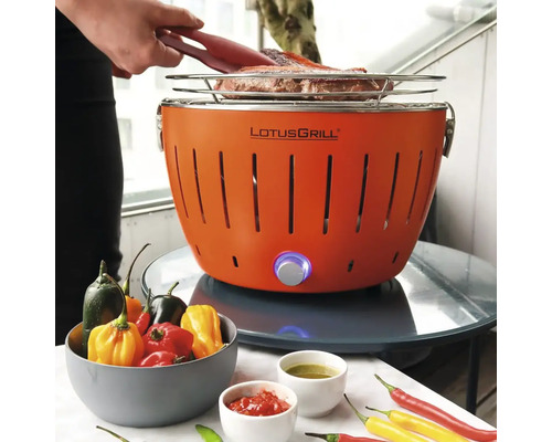 Grătar LotusGrill portocaliu cu alimente și boluri cu ingrediente