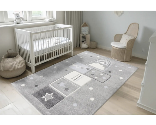 Cameră pentru copii cu pătuț, scaun și covor gri cu stele, nori și curcubeu