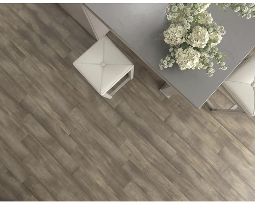 Imagine cu o cameră cu podea laminată cu aspect de lemn, o masă și un taburet