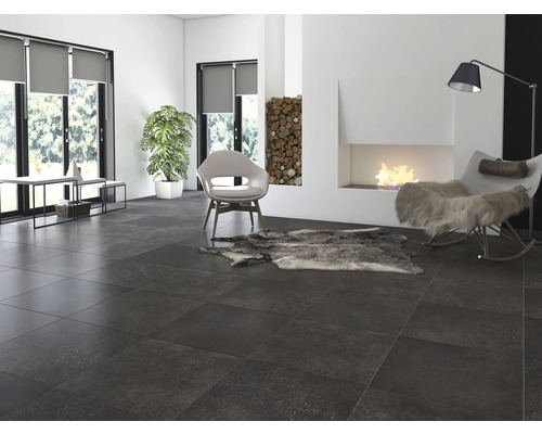 Cameră de zi cu podea cu gresie închisă la culoare, șemineu și locuri de ședere.