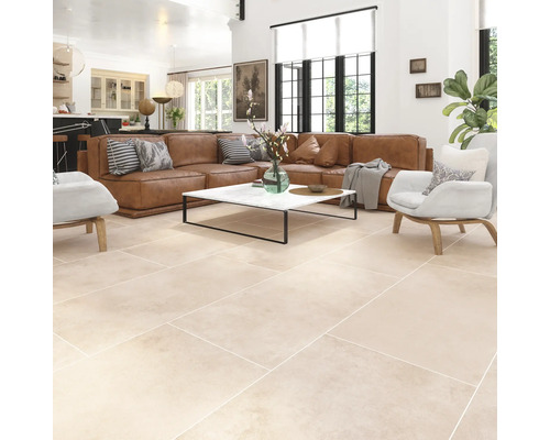 Cameră de zi luminoasă cu canapea din piele maro, măsuță de cafea cu blat de marmură și podea cu gresie.