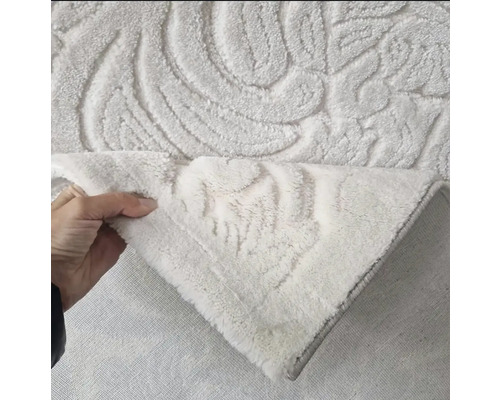 Covor de baie alb cu model în relief ridicat de o mână.