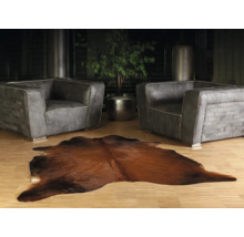 Living cu două fotolii din piele gri și un covor maro din piele de vacă