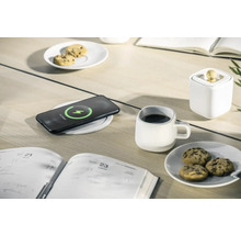 Scenă cu smartphone pe încărcător wireless, ceașcă, biscuiți și agendă