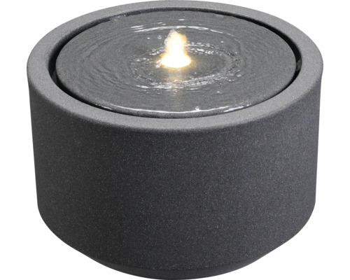 Fântână rotundă de interior din piatră cu apă și lumină