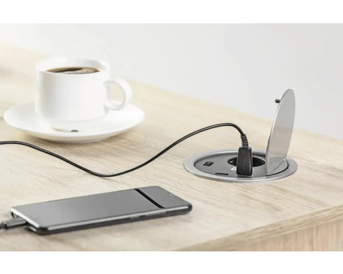 Masa cu priză încastrată, smartphone conectat și ceașcă de cafea