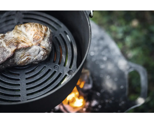 Bucată de carne pe grătar deasupra unui foc deschis