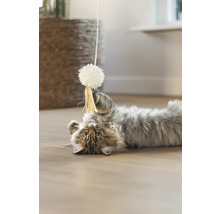 O pisică stă întinsă pe spate și se joacă cu o jucărie.