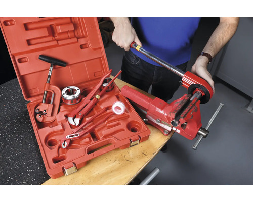 Set de filiere pentru țevi în cutie de scule cu o persoană care lucrează la o țeavă