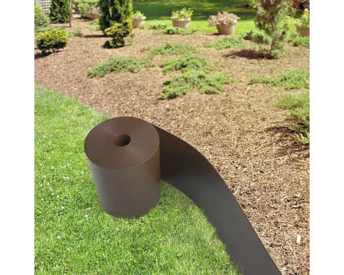 Peisaj de grădină cu gazon și strat de flori cu mulci și o rolă de bordură de gazon