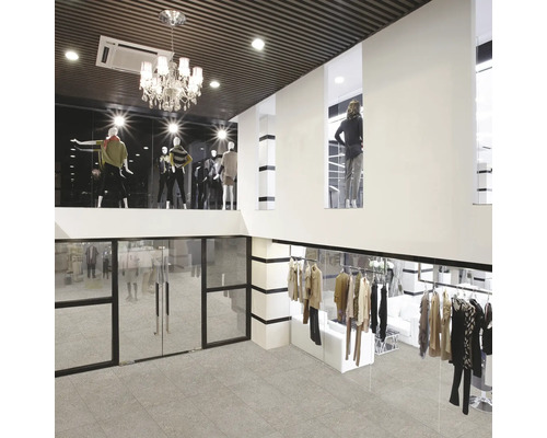 Imagine de interior a unui magazin de haine cu manechine, haine și gresie.