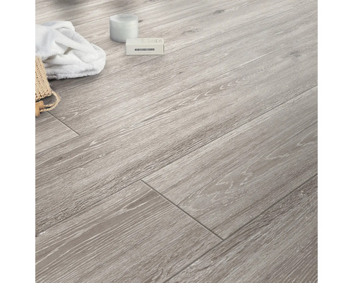 Pardoseală laminată deschisă la culoare cu aspect de lemn și accesorii de baie