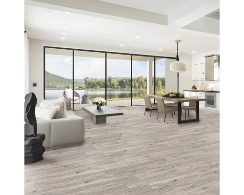 Living luminos cu podea din lemn, canapea, masă de sufragerie și vedere la un lac