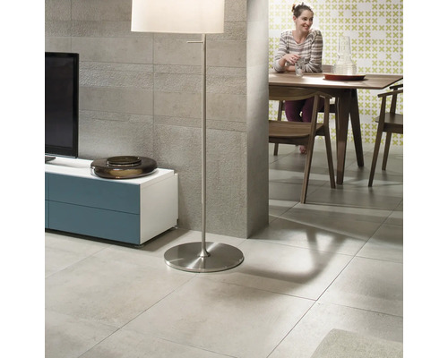 Cameră de zi cu gresie, lampă de podea, televizor și masă de sufragerie