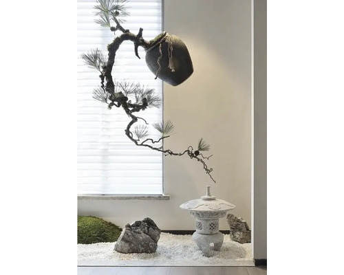 Scenă decorativă cu plantă, pietre și felinar de piatră pe pietricele albe