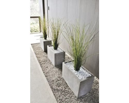 Șir de trei jardiniere dreptunghiulare cu ierburi ornamentale și pietre decorative albe pe un pat de pietriș