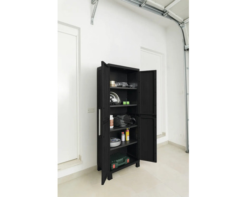 Dulap deschis, negru, pentru scule, cu rafturi și diverse obiecte într-o cameră luminoasă.