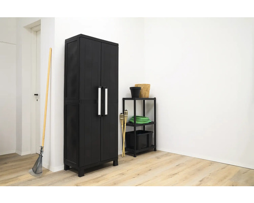 Fotografie cu un dulap negru pentru scule cu două uși și mânere argintii într-o cameră.