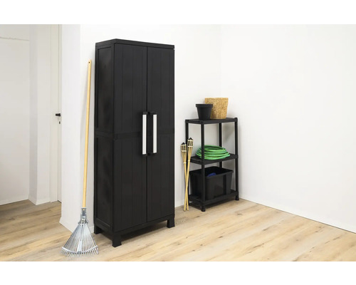 Scenă de grădină cu un dulap negru pentru scule, un raft și unelte de grădinărit.