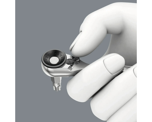 O mână ține o cheie mică Wera pentru biți.