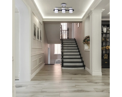 Fotografie de interior a unui hol cu scară și lampă de tavan