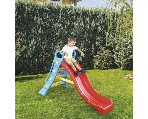 Băiat care alunecă pe un tobogan roșu pentru copii în grădină