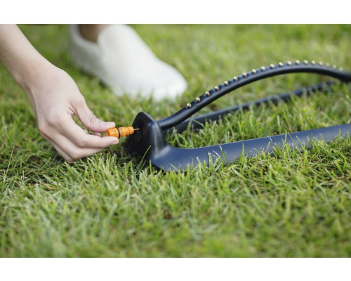 Aspersor de gazon cu piesă de reglare pe gazon