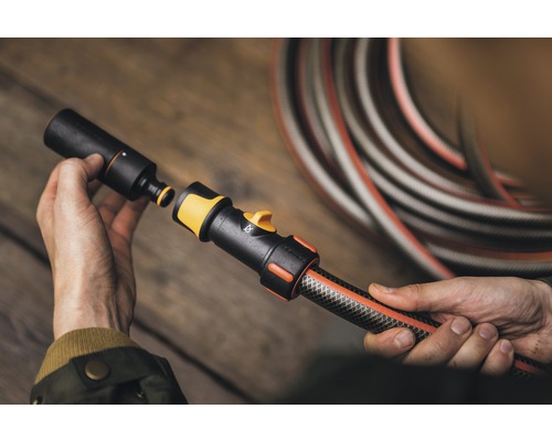 Persoană conectând furtunul de grădină cu cuplajul