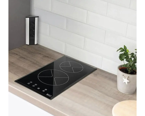 Plită neagră cu două zone de gătit într-o bucătărie luminoasă