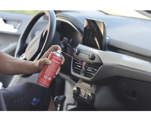 O persoană curăță orificiile de ventilație ale unei mașini cu un spray dezinfectant de la Rothenberger Sanifresh.