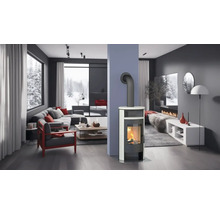 Cameră de zi luminoasă cu sobă de șemineu, canapea și vedere la un peisaj înzăpezit.