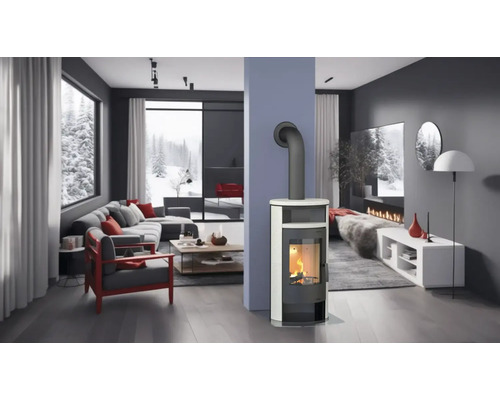 Cameră de zi luminoasă cu sobă de șemineu, canapea și vedere la un peisaj înzăpezit.