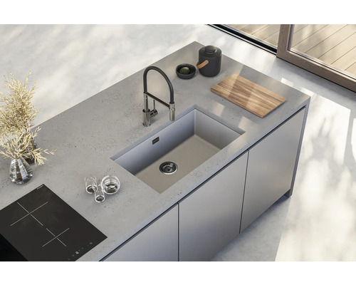 Insulă de bucătărie cu chiuvetă, robinet și plită într-o bucătărie modernă luminoasă.