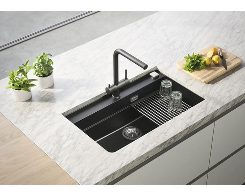 Chiuvetă cu baterie, suport pentru uscare, pahare, ierburi și lămâi pe un blat de lucru