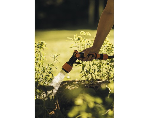 Udarea grădinii cu un pistol de stropit pentru grădină.
