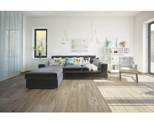 Cameră de zi cu canapea gri, fotoliu și bibliotecă într-un design luminos