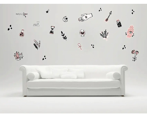 Cameră de zi cu o canapea albă și autocolante de perete cu motive ezoterice.