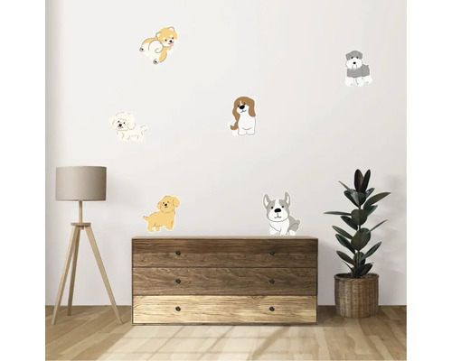 Autocolante decorative de perete cu câini deasupra unei comode cu lampă și plantă de interior.