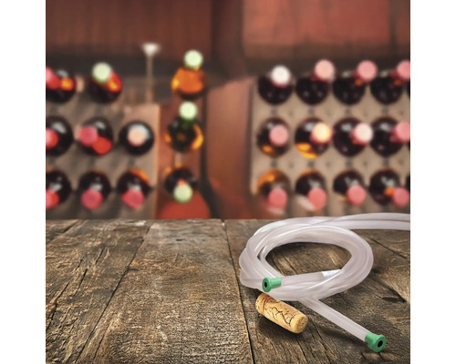 Sifon de vin cu furtun și dop de plută pe masă de lemn în fața unui raft de vinuri