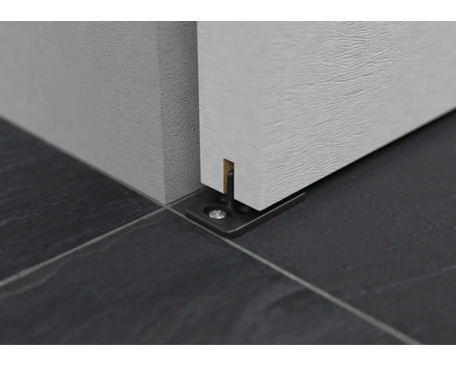 Detaliu al unui ghidaj de ușă glisantă pe podea.