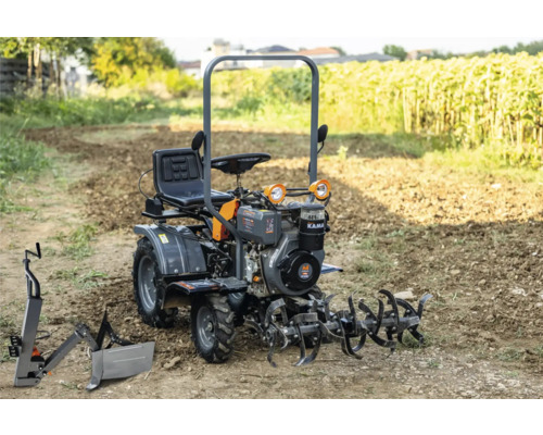 Motocultor cu scaun și accesorii pe un câmp