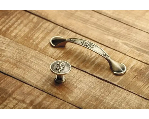 Mâner de mobilă și buton de mobilă cu model floral pe suprafață de lemn