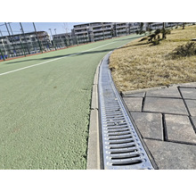 Imagine detaliată a unui sistem de canalizare lângă o alee și un teren de sport