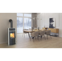 Cameră de zi cu sobă de ardere, masă de sufragerie și scaune sub o lampă suspendată.