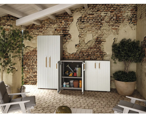 Scenă cu trei dulapuri de grădină din plastic pe o terasă pavată.