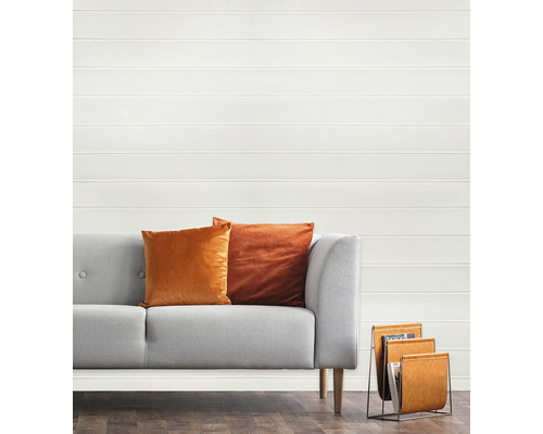 Canapea gri cu perne și suport de reviste în fața unui perete cu panouri