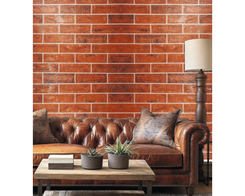 Living cu perete de cărămidă, canapea de piele, masă de lemn și lampadar